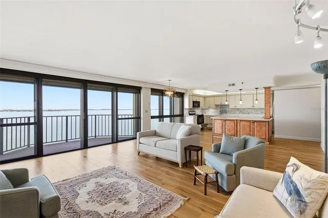 a kitchen with stainless steel appliances granite countertop a stove a sink and a refrigerator with wooden floor