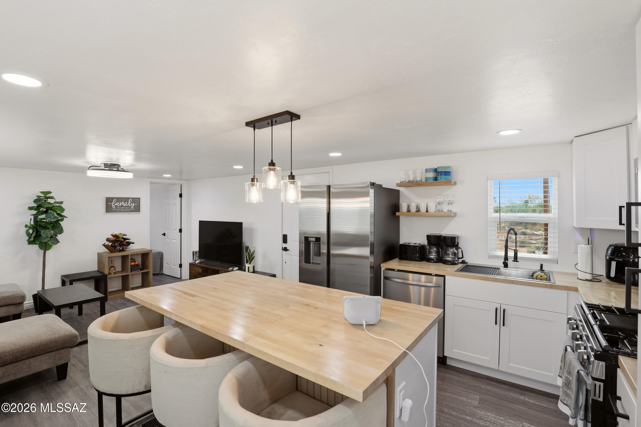 8620 South Sandario Road Tucson, AZ 85736 - Photo 10 of 26 a kitchen with stainless steel appliances kitchen island granite countertop a sink and a refrigerator