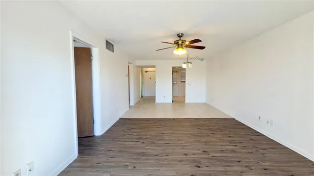 a view of an empty room with wooden floor