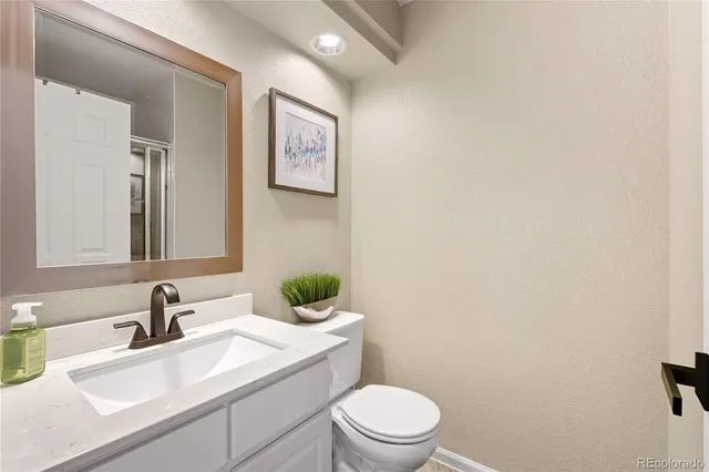 a bathroom with a toilet a sink and mirror