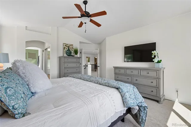 a bedroom with a bed a dresser and flat screen tv