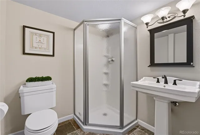 a bathroom with a toilet a sink a mirror and vanity