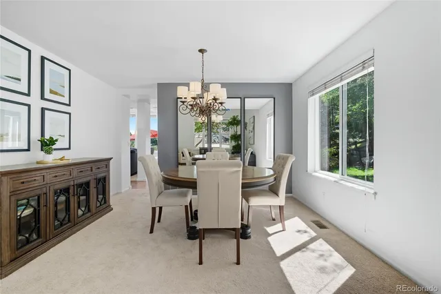 a dining room with furniture a chandelier and wooden floor