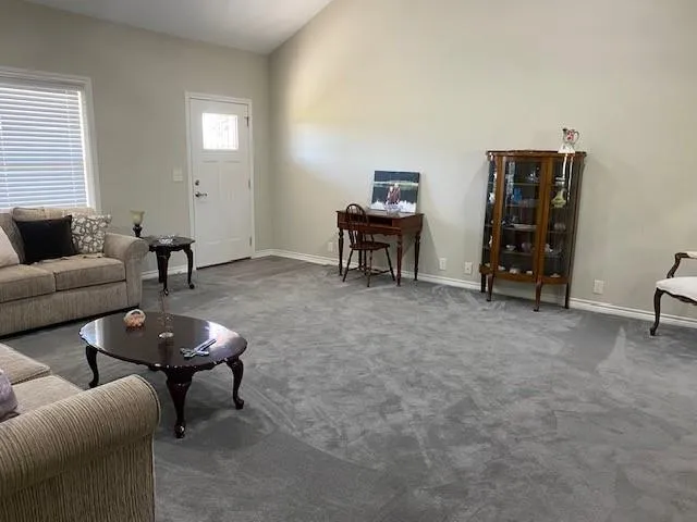 a living room with furniture a piano and a window