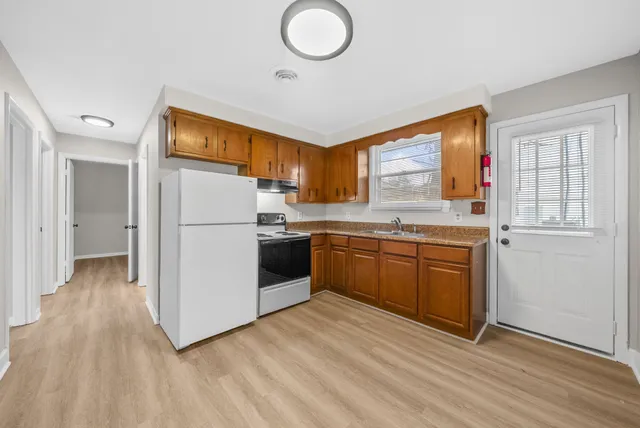 a kitchen with a sink a refrigerator and a stove