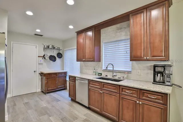 a kitchen with stainless steel appliances granite countertop a sink stove and cabinets