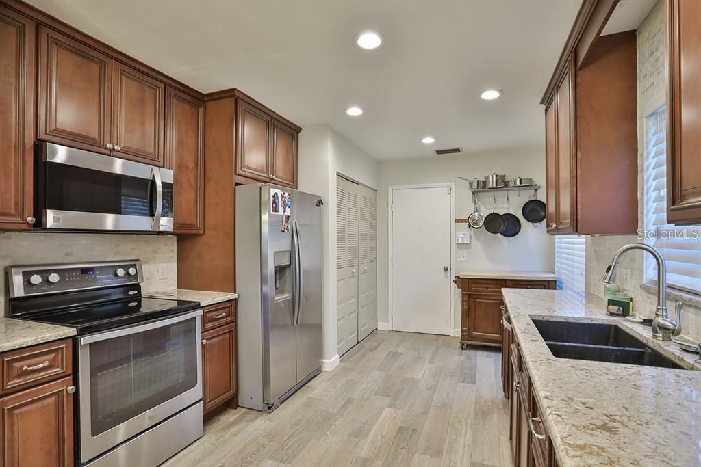 7920 George Washington Lane Tampa, FL 33637 - Photo 3 of 6 a kitchen with stainless steel appliances granite countertop a refrigerator stove and sink
