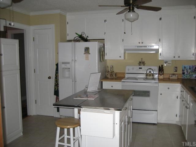 8605 Cheerful Court Raleigh, NC 27615 - Photo 4 of 12 a kitchen with stainless steel appliances granite countertop a sink a stove a refrigerator and island