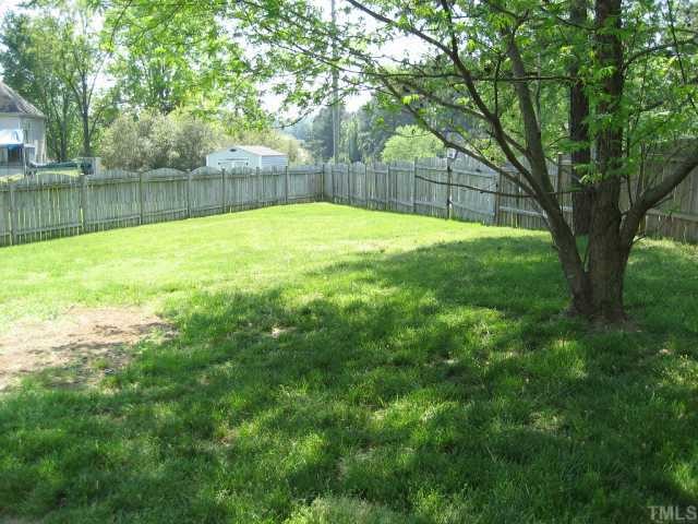 8605 Cheerful Court Raleigh, NC 27615 - Photo 7 of 12 a view of a backyard with a large tree and wooden fence