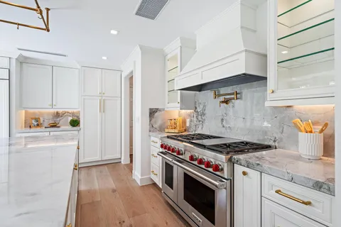 a large kitchen with stainless steel appliances lots of counter space sink and wooden floor