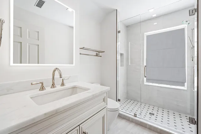 a bathroom with a sink a toilet and a mirror