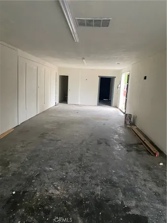 an empty room with windows and fireplace
