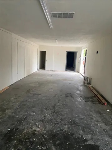 an empty room with windows and fireplace