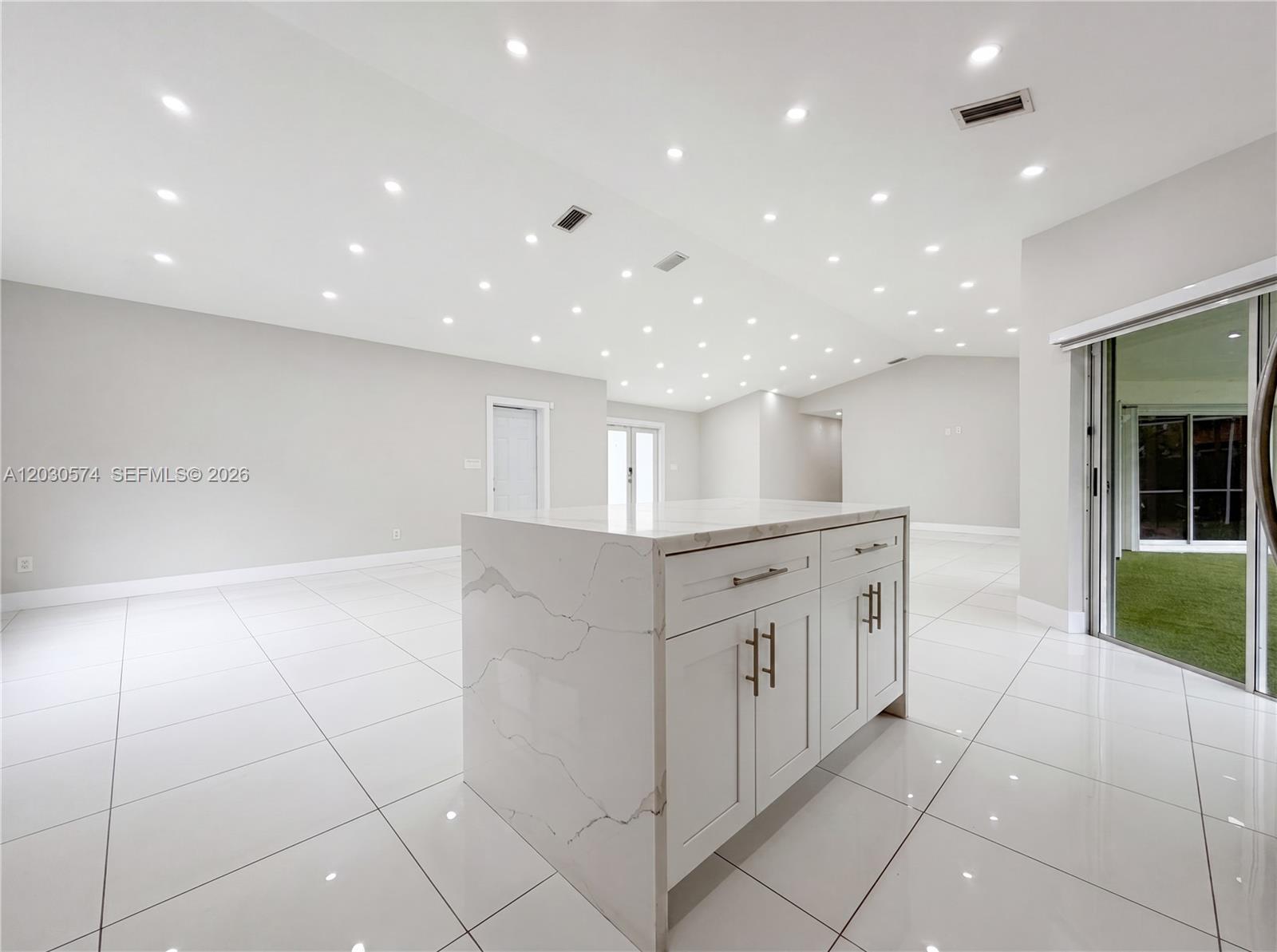 16571 Southwest 145th Avenue Miami, FL 33177 - Photo 10 of 25 a large white kitchen with stainless steel appliances a large counter top and a floors