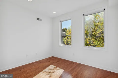 an empty room with window and wooden floor