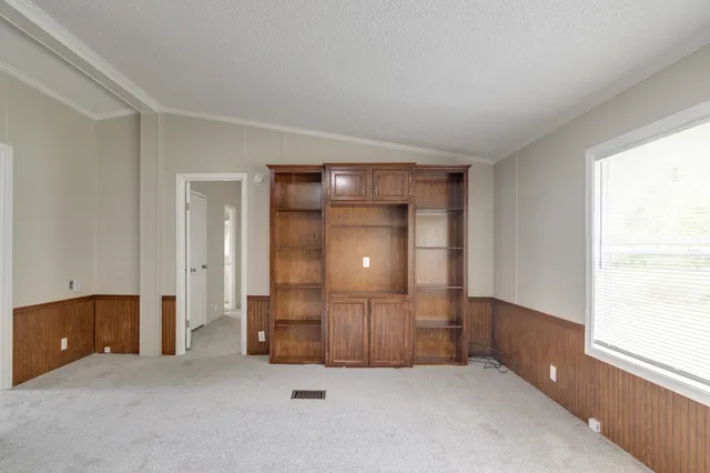 a view of an empty room with a fireplace and a window