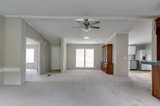 a view of a livingroom with a chandelier fan and windows