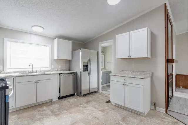 a kitchen with white cabinets and white appliances