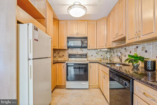 a kitchen with stainless steel appliances granite countertop a refrigerator and a stove
