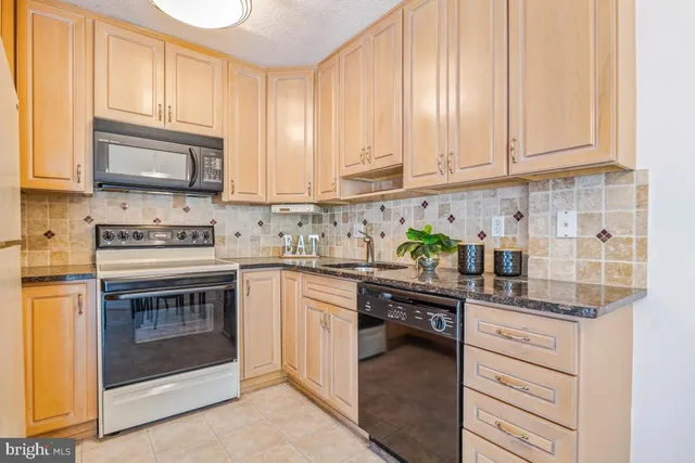 a kitchen with granite countertop cabinets stainless steel appliances and a sink