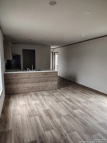 a kitchen with a sink and wooden floor