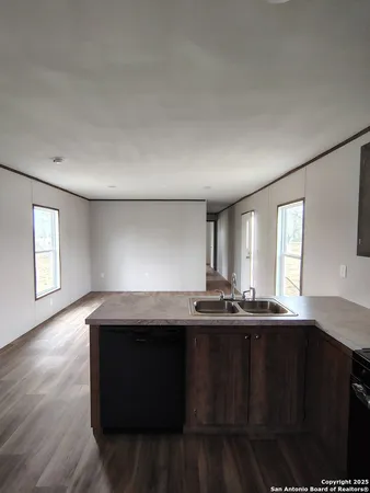 a kitchen with stainless steel appliances granite countertop a refrigerator a sink and a stove