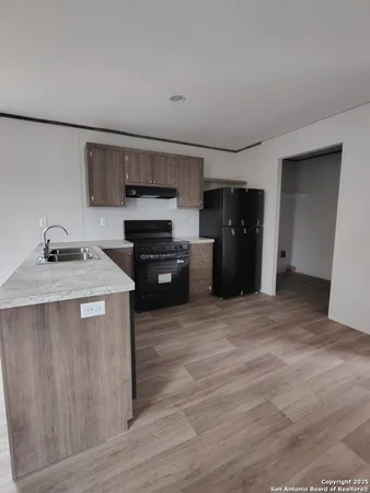 a kitchen with a refrigerator and a stove top oven