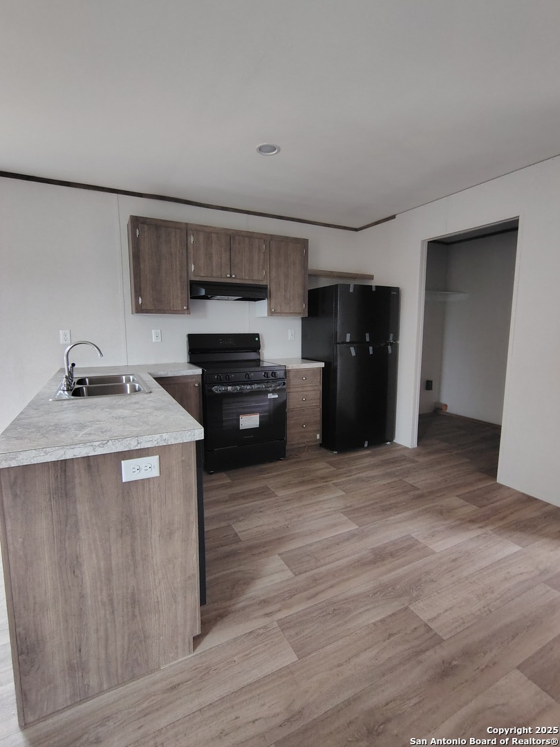152 County Road 2664 Devine, TX 78016 - Photo 6 of 17 a kitchen with stainless steel appliances granite countertop a refrigerator a sink and a stove