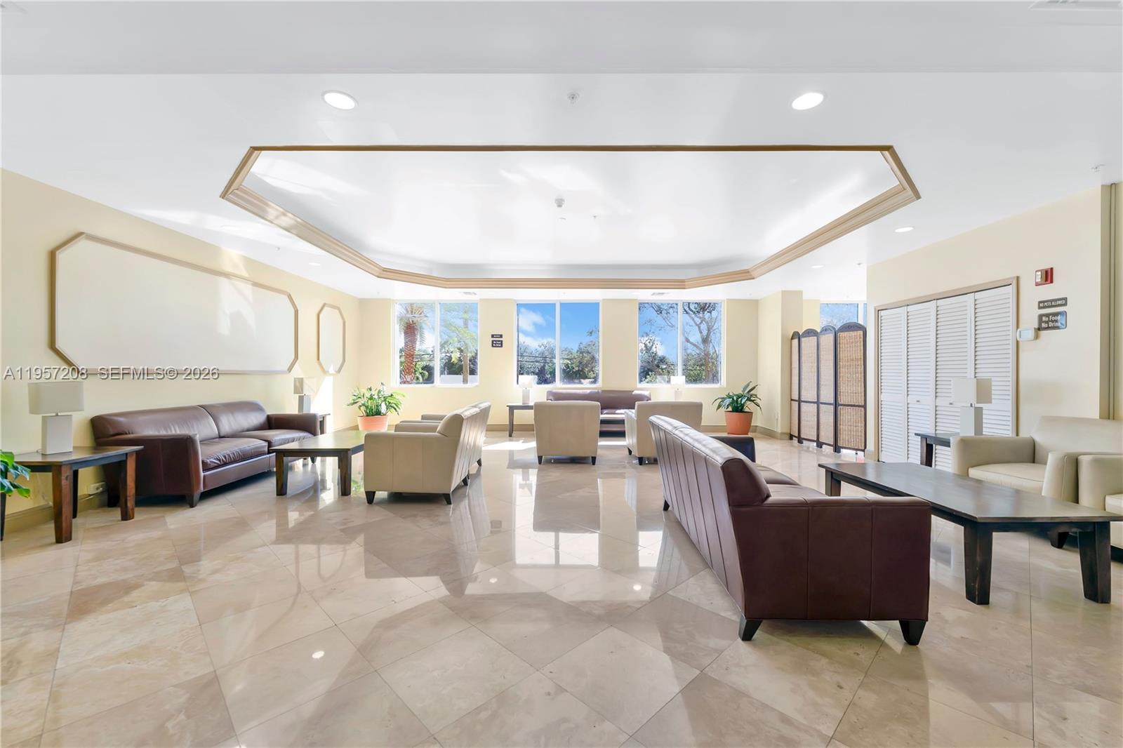 3500 Coral Way, Unit 710 Miami, FL 33145 - Photo 14 of 43 Spacious, sun-filled resident & guest lounge with ample seating and polished tile flooring—ideal for community gatherings.