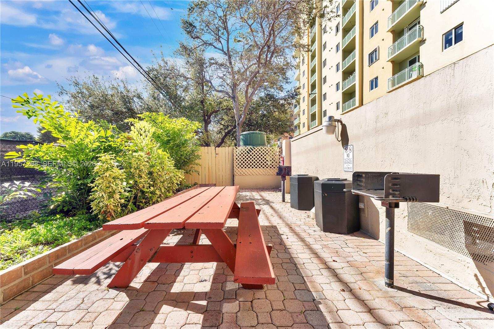3500 Coral Way, Unit 710 Miami, FL 33145 - Photo 22 of 39 Secure lobby with dual elevators, a spacious resident lounge, and an outdoor patio featuring grilling areas and picnic seating.