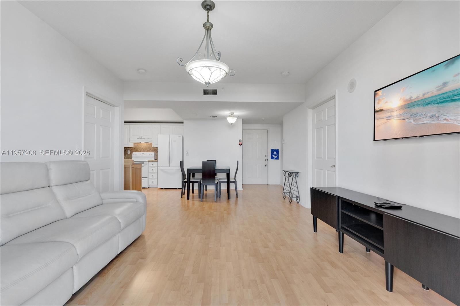 3500 Coral Way, Unit 710 Miami, FL 33145 - Photo 6 of 39 Versatile open-concept living space seamlessly blending kitchen, dining, and lounge areas with light flooring.