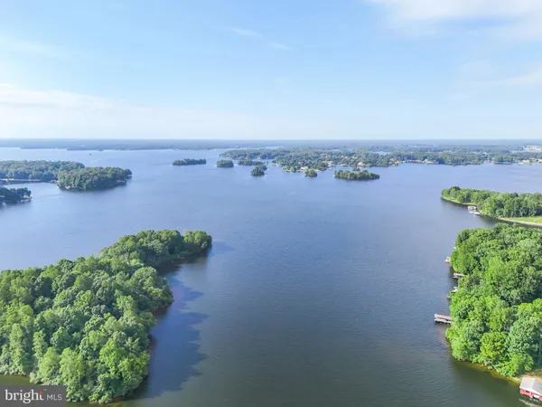 an aerial view of a houses with a yard and lake view