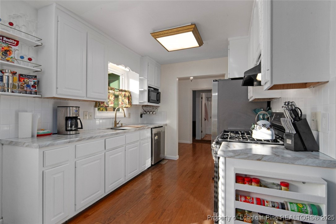 5978 Brookcliff Road Fayetteville, NC 28304 - Photo 11 of 38 a kitchen with kitchen island granite countertop a sink stainless steel appliances and cabinets