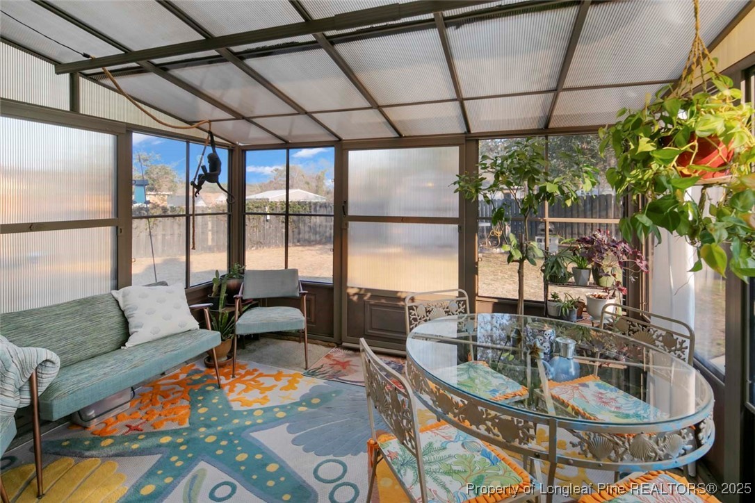 5978 Brookcliff Road Fayetteville, NC 28304 - Photo 19 of 38 a dining room with furniture a floor to ceiling window and potted plants