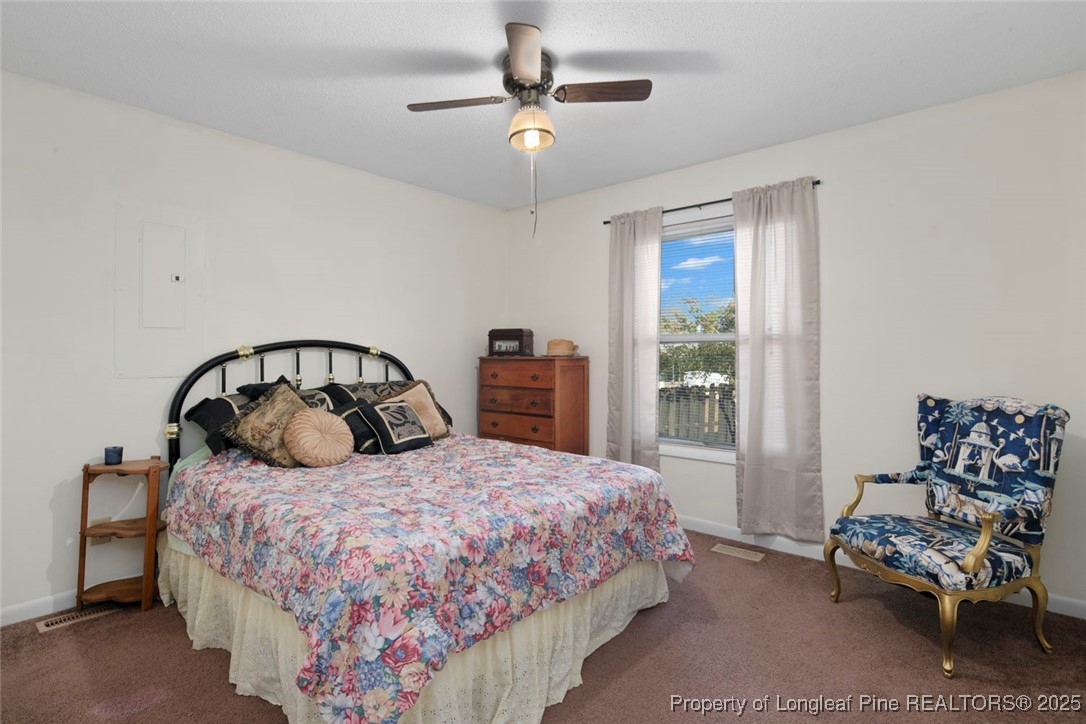 5978 Brookcliff Road Fayetteville, NC 28304 - Photo 26 of 38 a bedroom with a bed and a chandelier
