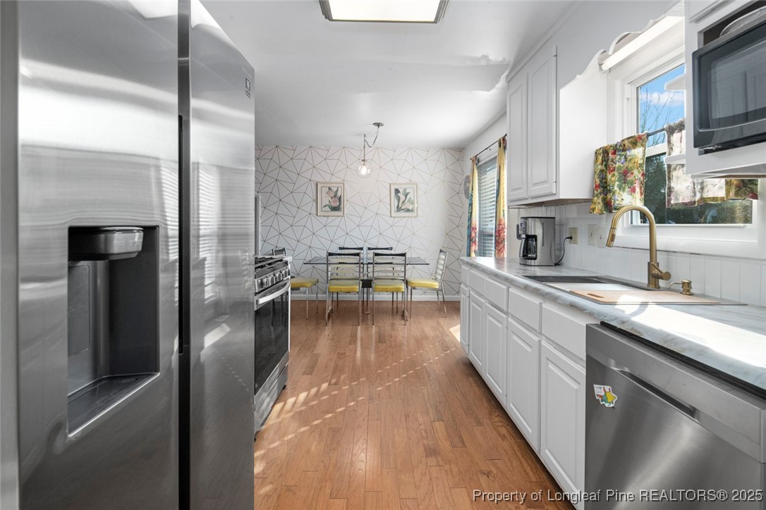 5978 Brookcliff Road Fayetteville, NC 28304 - Photo 8 of 38 a large kitchen with stainless steel appliances kitchen island granite countertop a large counter top a stove and a refrigerator