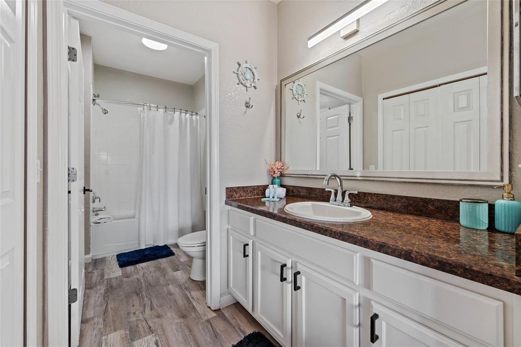 14200 Avalon Road, Unit 409 Winter Garden, FL 34787 - Photo 24 of 33 a bathroom with a granite countertop sink and a mirror