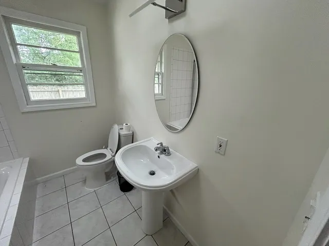a bathroom with a sink a toilet and a mirror