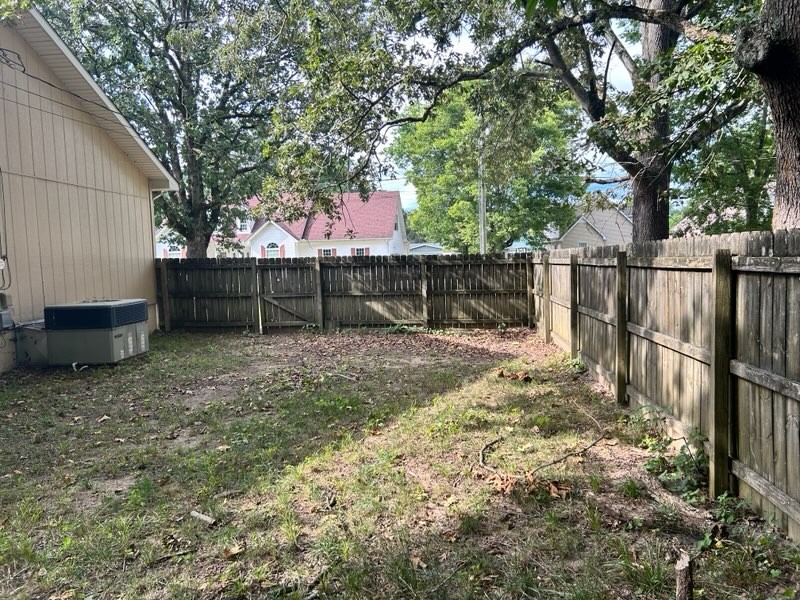 303 Willow Street Manchester, TN 37355 - Photo 14 of 15 a view of backyard with wooden fence and a large tree