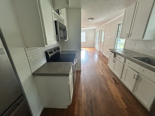 a kitchen with sink cabinets and wooden floor