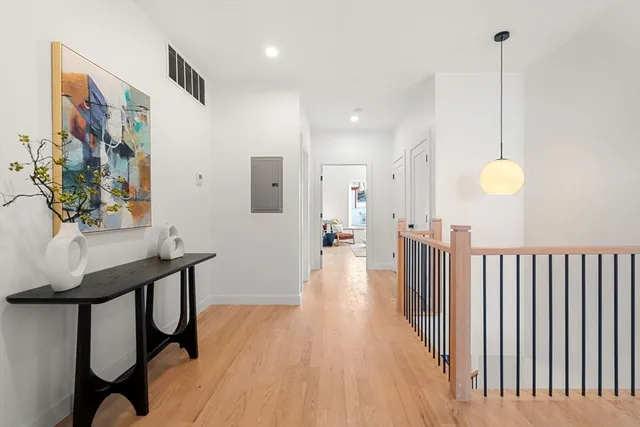 a view of a hallway with furniture and wooden floor