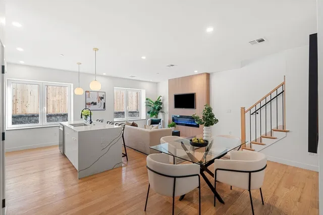 a living room with furniture a flat screen tv and kitchen view