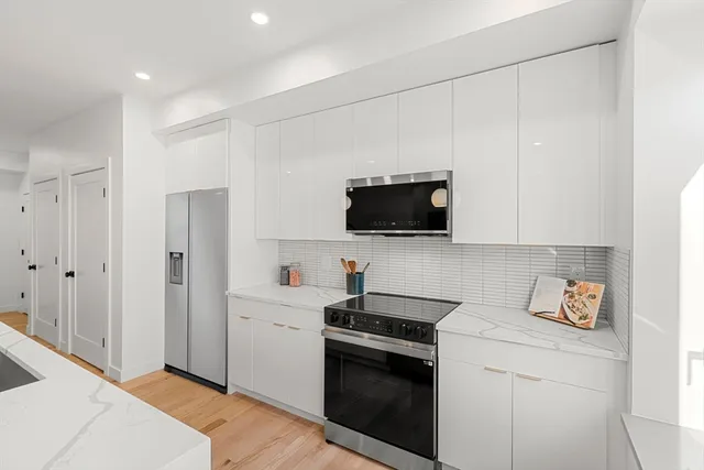 a kitchen with stainless steel appliances a stove microwave and white cabinets