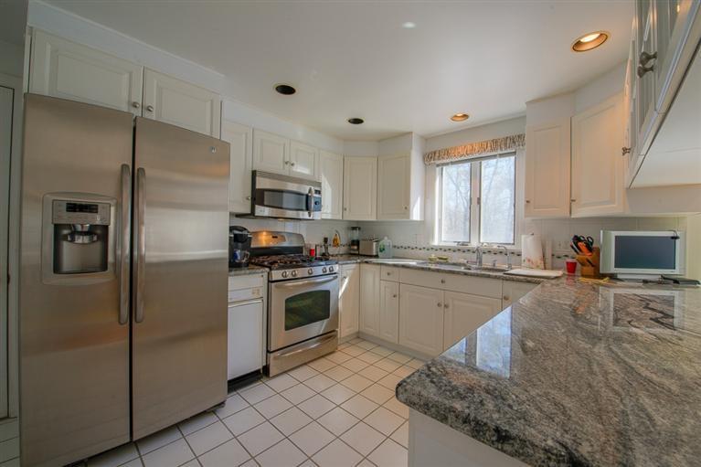 126 River Ridge Road Marstons Mills, MA 02648 - Photo 10 of 33 a kitchen with granite countertop white cabinets and stainless steel appliances