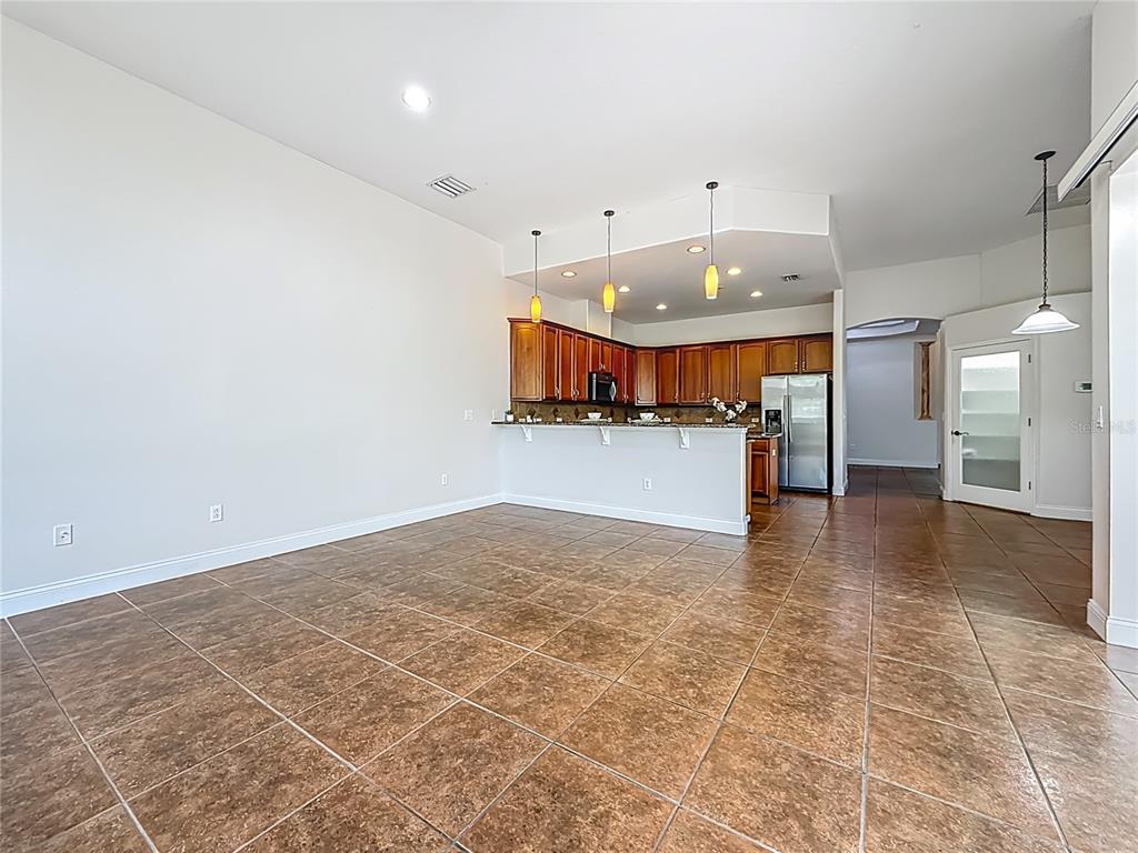 20626 Longleaf Pine Avenue Tampa, FL 33647 - Photo 23 of 86 an empty room with a kitchen view and a chandelier