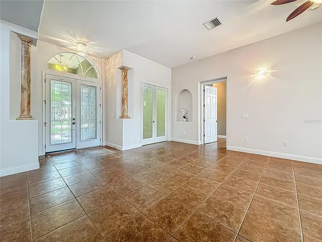 a view of a room with a ceiling fan and window