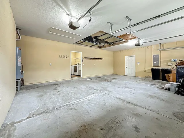 a view of an empty room and chandelier fan
