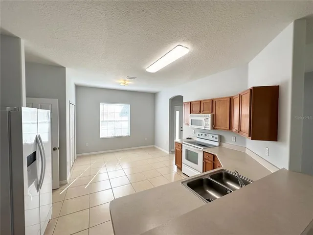 a view of a kitchen with a sink and a refrigerator