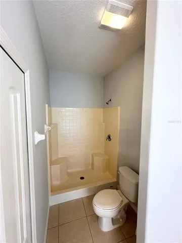 a bathroom with a granite countertop toilet and a shower