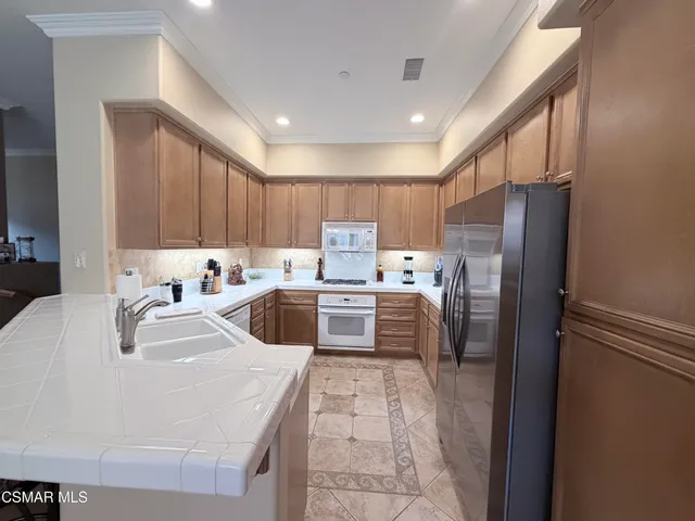 a kitchen with a refrigerator sink and cabinets
